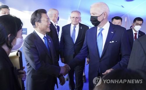 En la imagen, tomada el 30 de octubre de 2021, se muestra al entonces presidente de Corea del Sur, Moon Jae-in (izda.), estrechando la mano del presidente estadounidense, Joe Biden, al margen de la cumbre del G-20, en Roma.