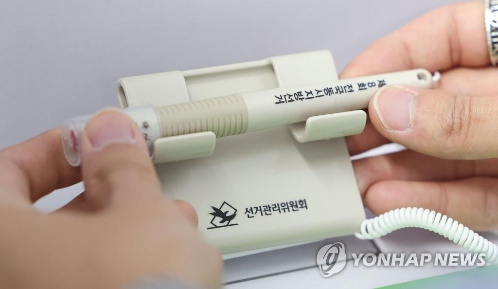 Un funcionario electoral verifica, el 25 de mayo de 2022, un dispositivo de marcado de papeletas en un colegio electoral en Seúl.