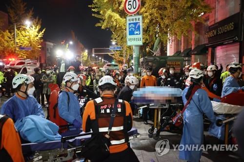 Los rescatistas trasladan a las personas heridas, en el barrio de Itaewon, en el centro de Seúl, el 30 de octubre de 2022, tras una avalancha humana durante las fiestas por la Noche de Brujas que dejó, al menos, 149 víctimas mortales.
