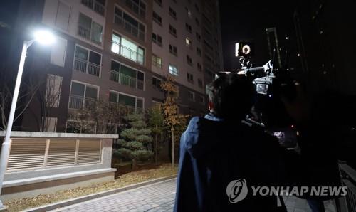 Un periodista observa la residencia de un ex jefe de personal de Lee Jae-myung, líder del principal partido opositor, el Partido Democrático, en Seongnam, al sur de Seúl, quien fue hallado muerto el 9 de marzo de 2023.