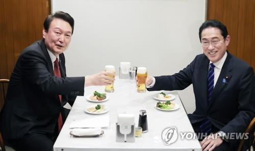 El presidente surcoreano, Yoon Suk Yeol (izda.), y el primer ministro japonés, Fumio Kishida, brindan en un restaurante tras su cumbre, el 16 de marzo de 2023, en la capital japonesa, Tokio.