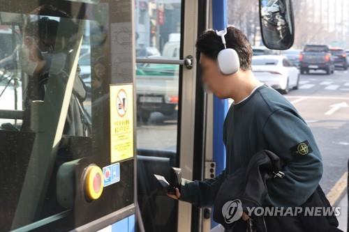 La foto de archivo muestra a una persona sin mascarilla subiendo al autobús, el 20 de marzo de 2023, en Seúl, a medida que el Gobierno levantó el mandato del uso obligatorio de mascarillas en el transporte público.