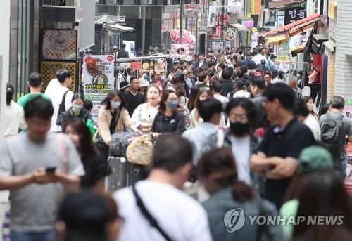 La gente camina, el 21 de mayo de 2023, por una calle abarrotada del famoso barrio turístico de Myeongdong, en el centro de Seúl. 