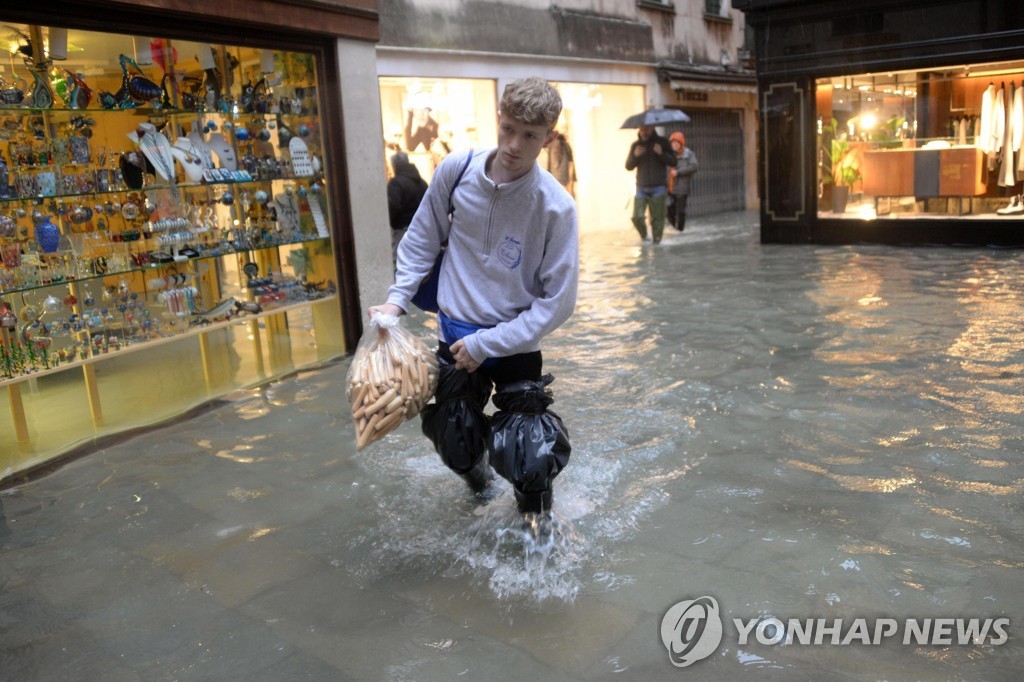 물에 잠긴 베네치아 거리를 걷는 사람들. [AP=연합뉴스]