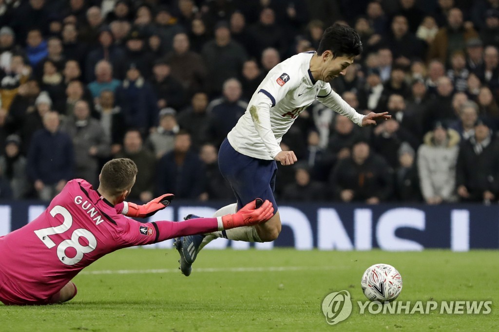 In this Associated Press photo, Son Heung-min of Tottenham Hotspur (R) falls down following contact with Southampton goalkeeper Angus Gunn in the fourth round of the FA Cup at Tottenham Hotspur Stadium in London on Feb. 5, 2020. (Yonhap)