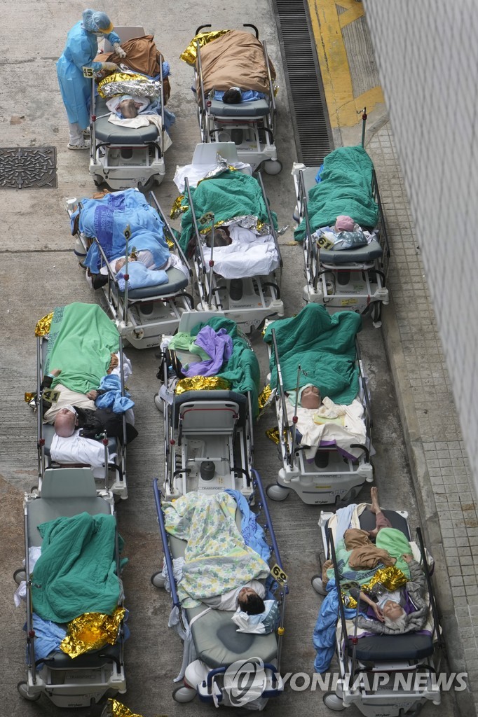 (AP=연합뉴스) 16일 홍콩의 한 병원 앞에 코로나19 환자들이 이동식 침대에 누운 채 대기하는 모습. 
