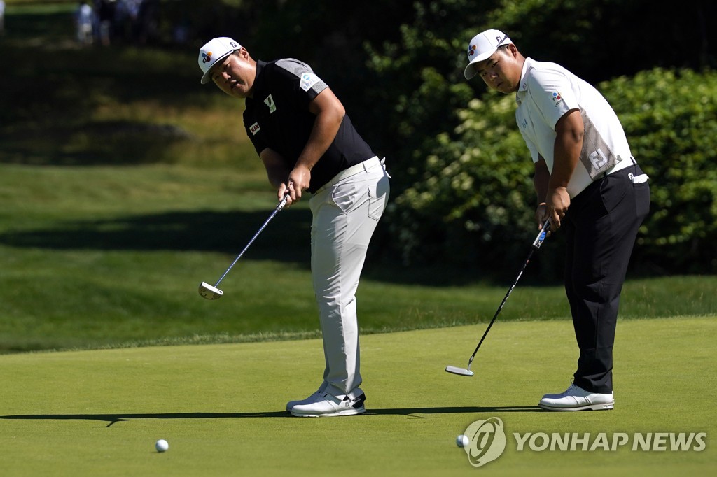 In this Associated Press file photo from June 14, 2022, Im Sung-jae (L) and Kim Joo-hyung of South Korea putt on the 17th green during the practice round prior to the U.S. Open at The Country Club in Brookline, Massachusetts. (Yonhap)