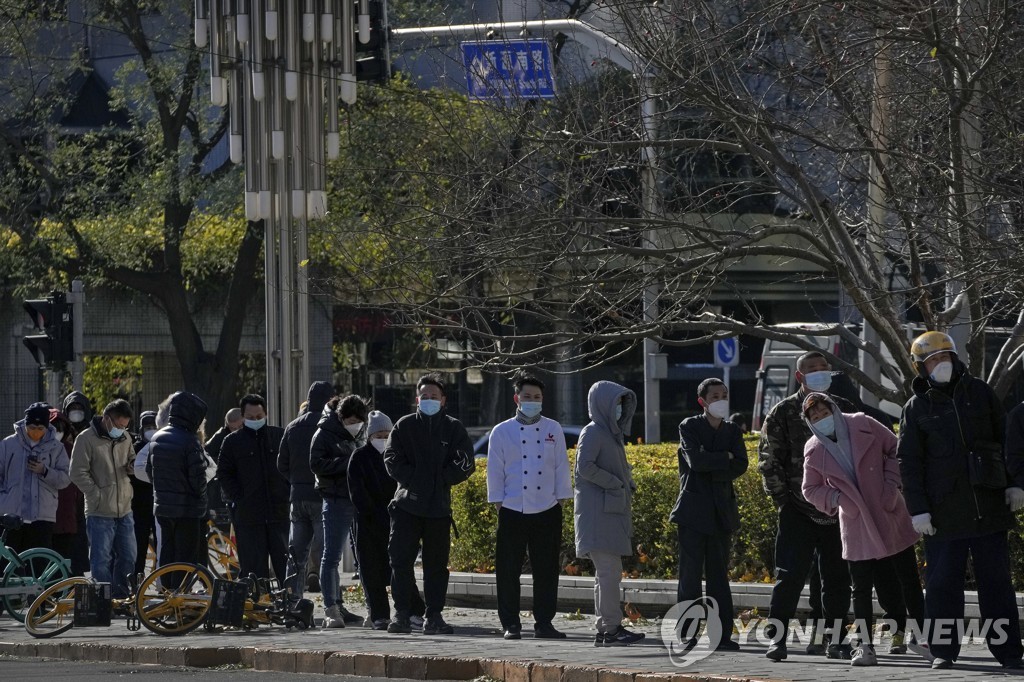 (AP=연합뉴스) 지난달 30일 추위가 몰아닥친 중국 베이징에서 주민들이 코로나19 검사를 받기 위해 길게 줄을 선 모습.