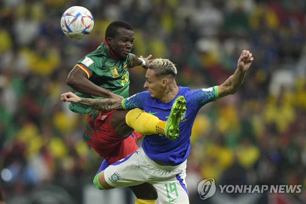 In this Associated Press photo, Tolo Nouhou of Cameroon (L) and Antony of Brazil battle for the ball during their countries' Group G match at the FIFA World Cup at Lusail Stadium in Lusail, north of Doha, on Dec. 2, 2022. (Yonhap)