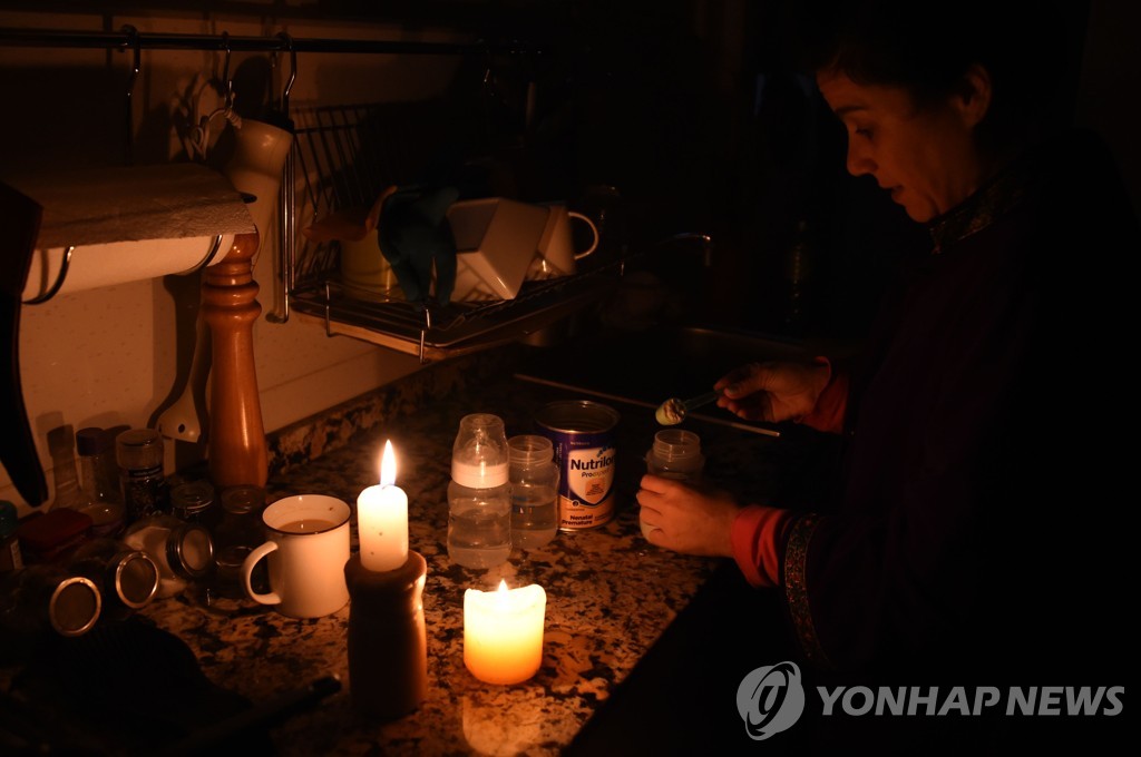 정전 속에 촛불에 불을 붙이는 우루과이 시민[AFP=연합뉴스] 