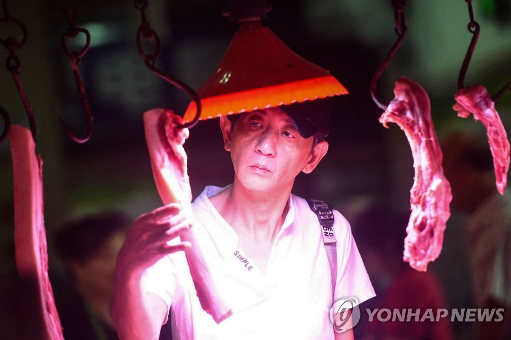 2019년 9월 10일 중국 항저우의 시장에서 한 남성이 정육점에 걸린 돼지고기를 살피고 있다. [AFP=연합뉴스자료사진]