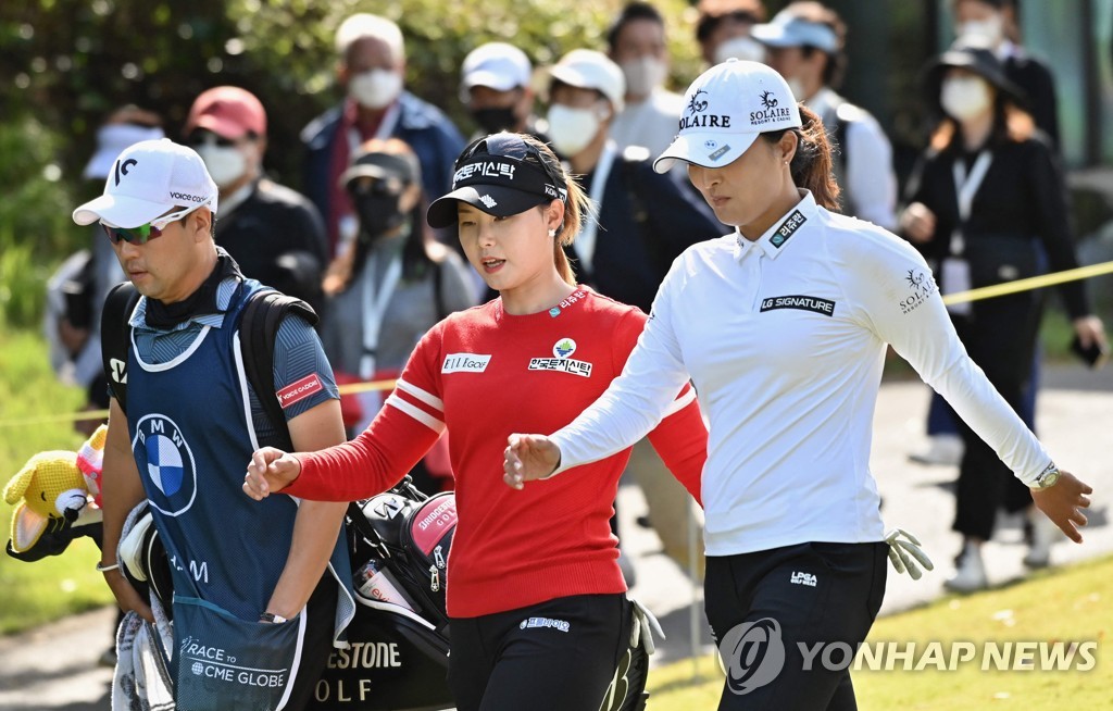 In this AFP photo, Ko Jin-young (R) and Lim Hee-jeong (C) of South Korea walk off the fifth tee during the final round of the BMW Ladies Championship at LPGA International Busan in Busan, some 450 kilometers southeast of Seoul, on Oct. 24, 2021. (Yonhap)
