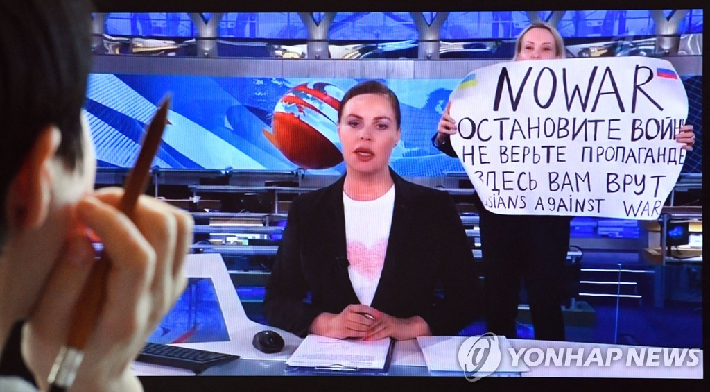 러시아 뉴스 중 반전 메시지를 들고 나타난 방송국 직원 