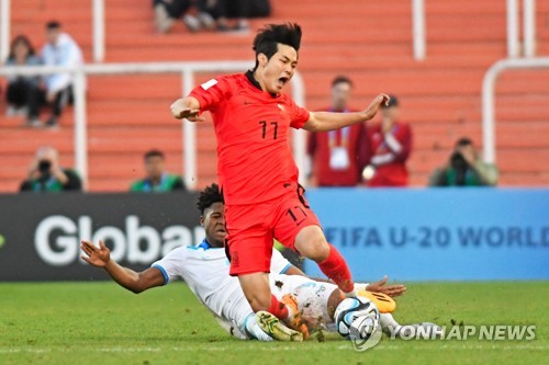 In this AFP photo, Kang Seong-jin of South Korea (R) is tackled by Exon Arzu of Honduras during a Group F match at the FIFA U-20 World Cup at Estadio Malvinas Argentinas in Mendoza, Argentina, on May 25, 2023. (Yonhap)