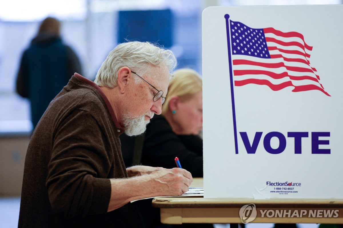 En esta fotografía publicada por AFP, un hombre llena su boleta durante la votación anticipada para las elecciones generales de Estados Unidos en un colegio electoral de la escuela secundaria Ottawa Hills en Grand Rapids, Michigan, el 3 de noviembre de 2024. (Yonhap)