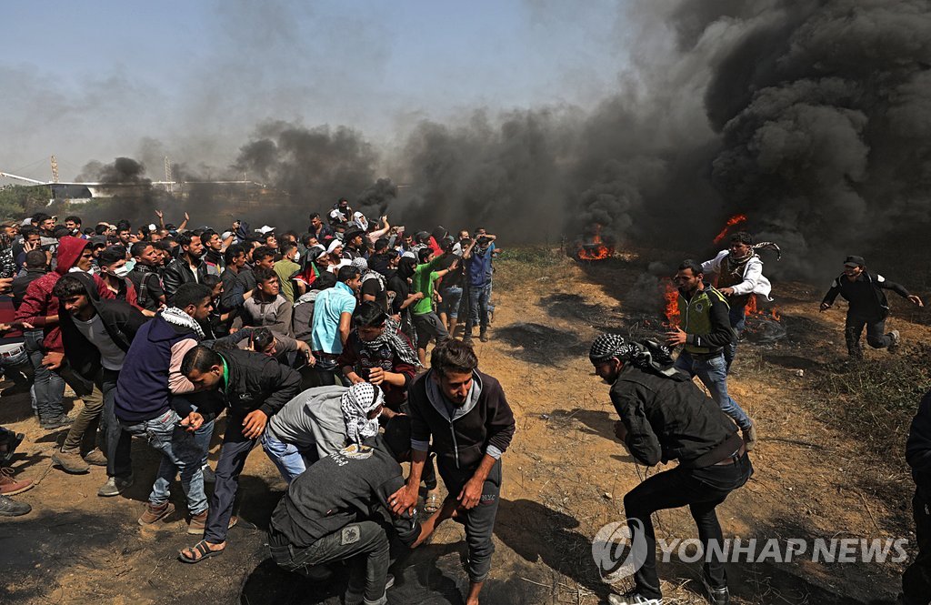 6일(현지시간) 가자지구와 이스라엘 간 보안장벽 인근에서 이스라엘군과 대치하고 있는 팔레스타인 시위대 [EPA=연힙뉴스]