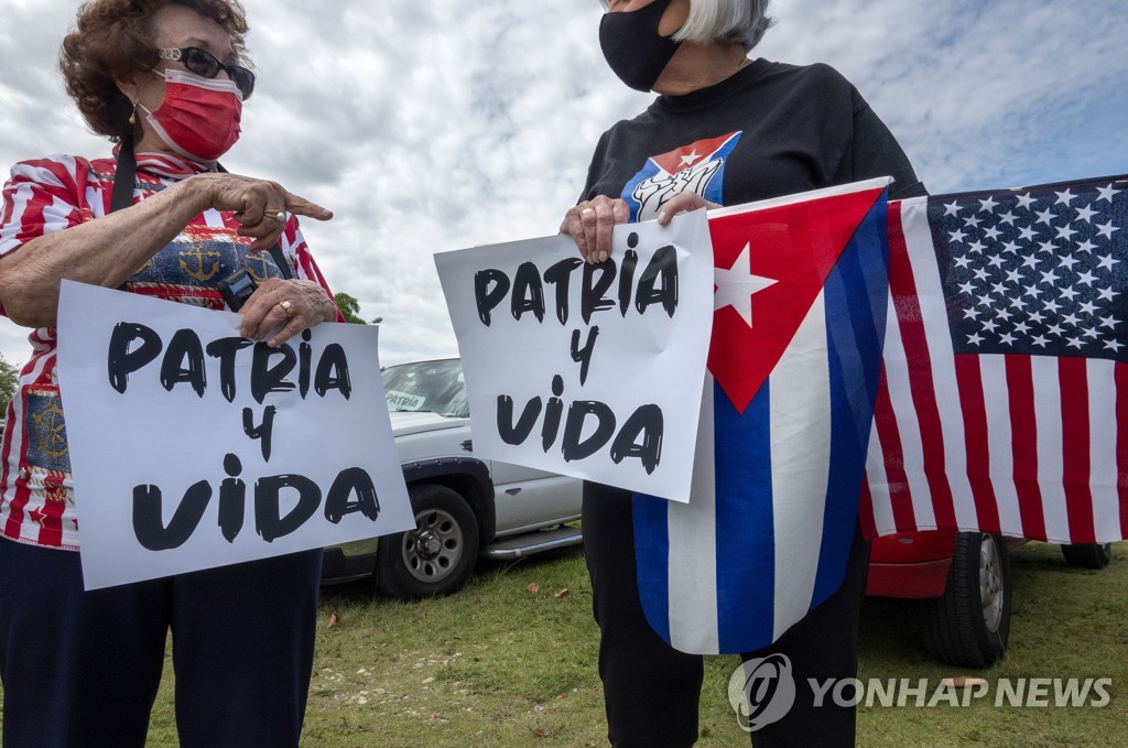 쿠바 반정부 시위를 지지하는 마이애미 주민들이 '조국과 삶' 구호가 써진 손팻말을 들고 있다.