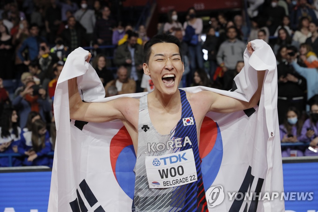 In this EPA photo, Woo Sang-hyeok of South Korea (C) celebrates after winning gold in the men's high jump at the World Athletics Indoor Championships at Stark Arena in Belgrade on March 20, 2022. (Yonhap)