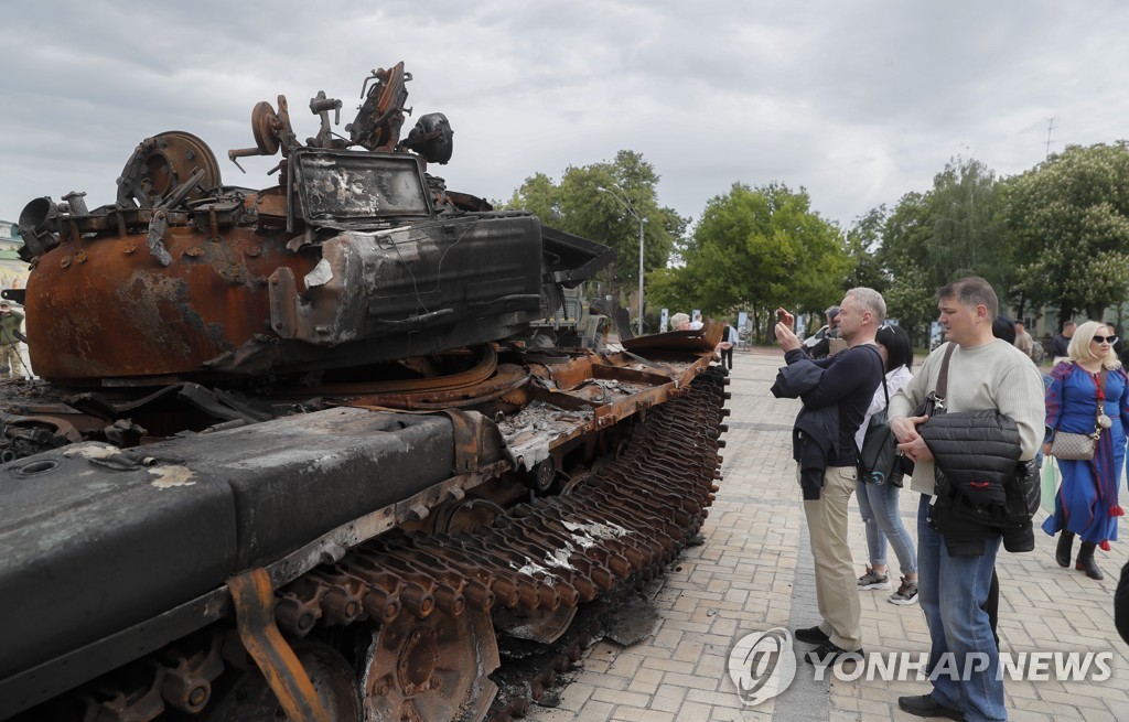 파괴된 러 탱크 바라보는 우크라 시민들