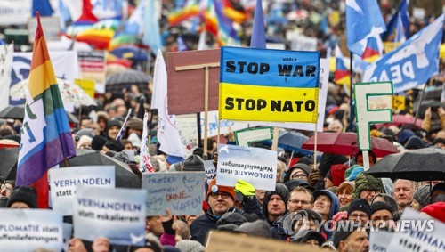 25일(현지시간) 독일 수도 베를린 브란덴부르크 문 앞에서 우크라이나 군사 지원 중단 촉구하는 시위대