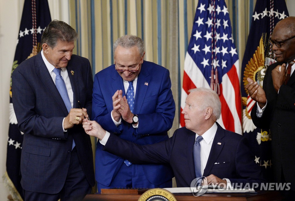 지난해 8월 인플레이션 감축법(IRA) 서명 후 조 맨친 상원의원(좌)에게 펜을 건네는 조 바이든 미국 대통령(우측 두 번째) [UPI 연합뉴스 자료사진]