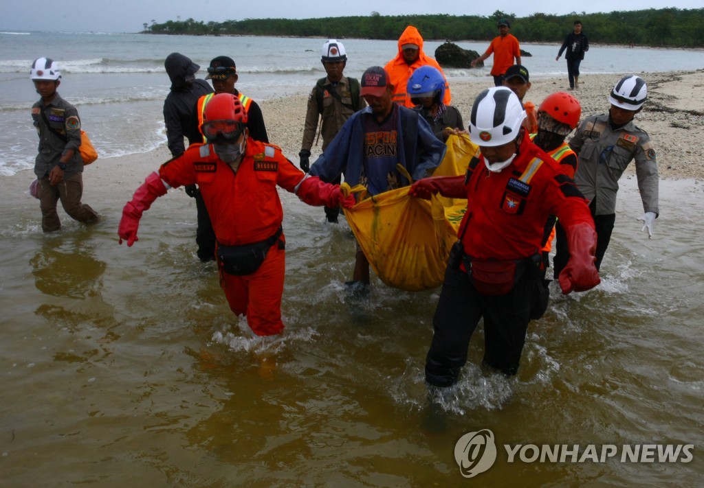 2018년 12월 25일 인도네시아 반텐 주 판데글랑 지역 탄중 르숭 해변에서 구조대원들이 쓰나미에 휩쓸려 목숨을 잃은 주민의 시신을 발견해 옮기고 있다. [로이터=연합뉴스]