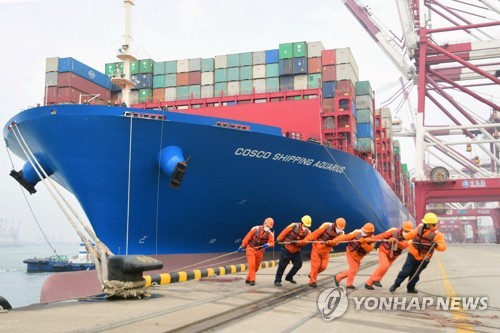 11일(현지시간) 중국 칭다오 항구에서 마스크를 낀 작업자들이 일하고 있다. [로이터=연합뉴스 자료사진]