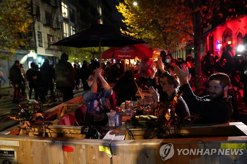미국 뉴욕시 한 식당의 야외 테이블에서 식사하는 시민들