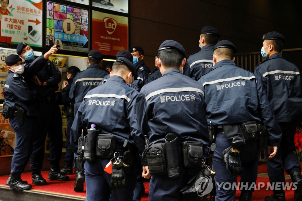 (로이터=연합뉴스) 홍콩 경찰이 29일 오전 압수수색을 위해 홍콩 민주진영 매체 입장신문의 사무실로 들어서는 모습. 
