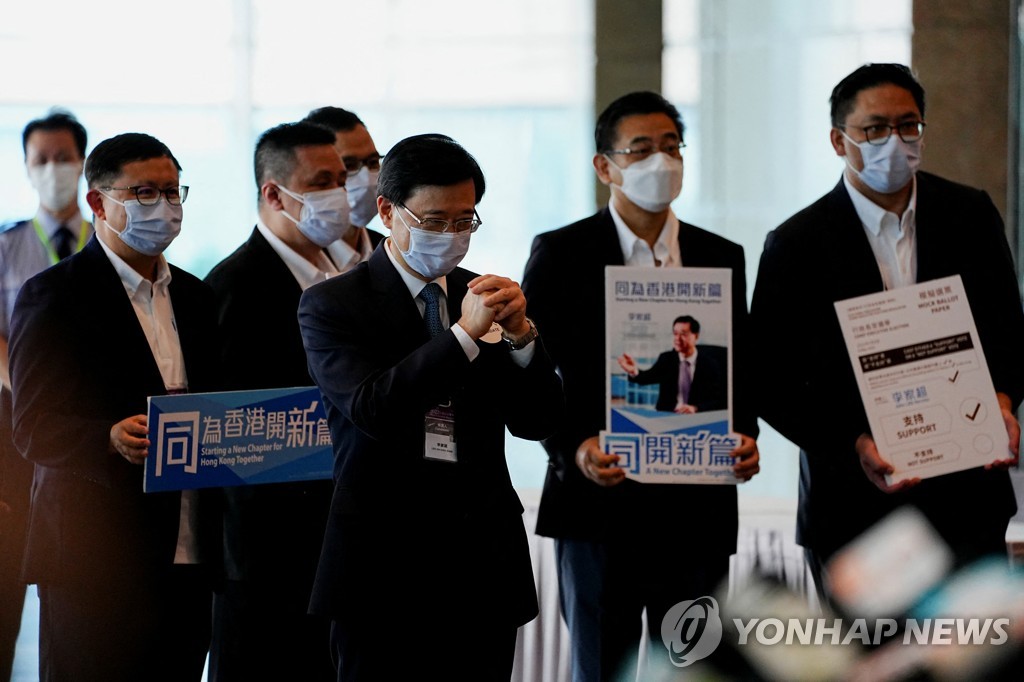 (로이터=연합뉴스) 8일 홍콩 행정장관 선거가 열리는 홍콩컨벤션센터에서 존 리(가운데) 후보가 지지자들에 인사하는 모습.