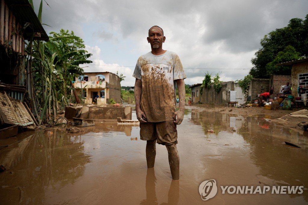진흙탕물에 우두커니 서 있는 에콰도르 주민