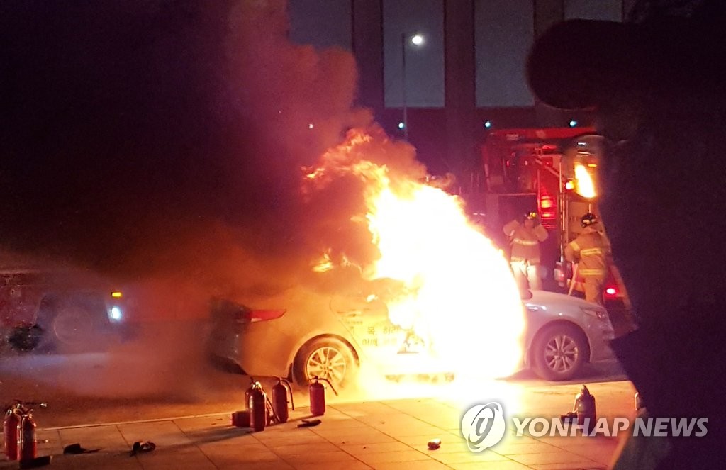 A taxi burns near Gwanghwamun Station in central Seoul on Jan. 9, 2019, in this photo provided by a reader. (Yonhap)