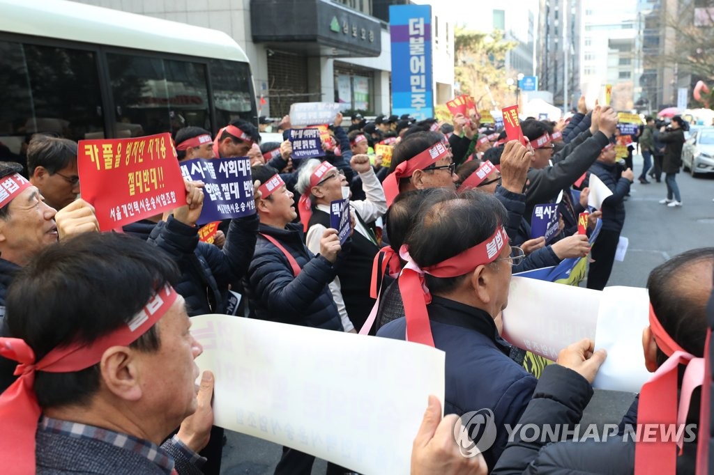Self-employed taxi drivers stage a protest near the ruling Democratic Party headquarters in Yeouido, western Seoul, on March 8, 2019, in objection to the agreement between the government, carpool app operator and a taxi drivers' association to partially allow the carpool service. (Yonhap)