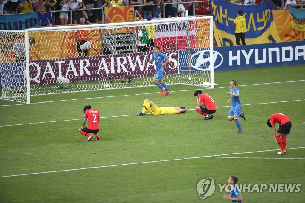 South Korean players (in red and yellow) react to Ukraine's third goal in the FIFA U-20 World Cup final at Lodz Stadium in Lodz, Poland, on June 15, 2019. (Yonhap)