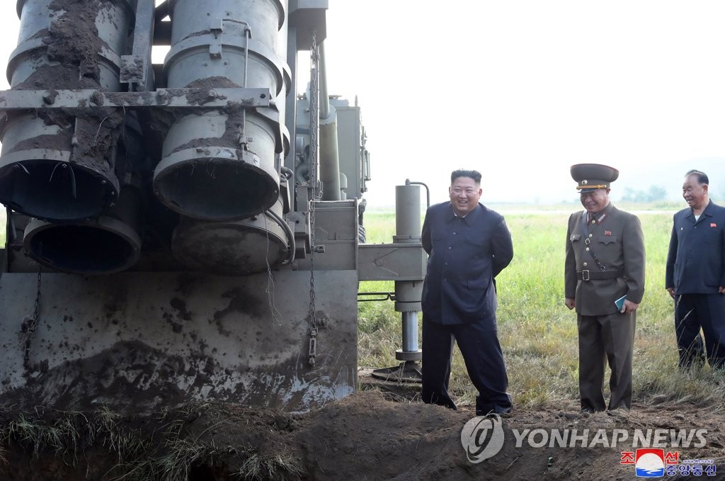 North Korean leader Kim Jong-un (L) stands next to a multiple rocket launcher the North tested on Sept. 10, 2019, in this photo released by its state media. It shows one of the four launching tubes covered, stirring speculation that the North might have fired three projectiles the previous day. (For Use Only in the Republic of Korea. No Redistribution) (Yonhap)