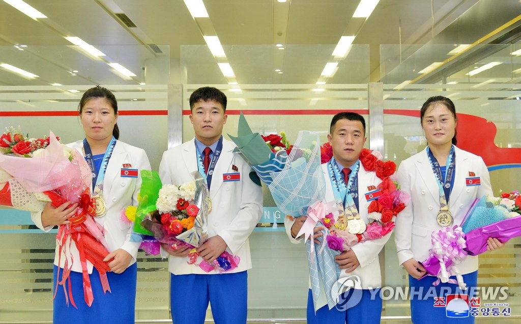 In this file photo, taken on Sept. 30, 2019, and released by the Korean Central News Agency, North Korean weightlifters pose for a photo after returning home from the 2019 World Weightlifting Championship of the International Weightlifting Federation in Pattaya, Thailand. They earned seven golds, twelve silvers and five bronzes at the championship. (For Use Only in the Republic of Korea. No Redistribution) (Yonhap)