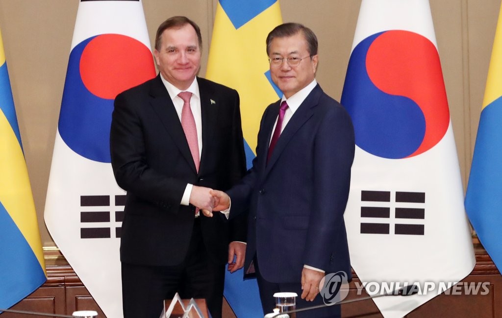 South Korean President Moon Jae-in (R) shakes hands with Swedish Prime Minister Stefan Lofven at Cheong Wa Dae in Seoul on Dec. 18, 2019. (Yonhap)