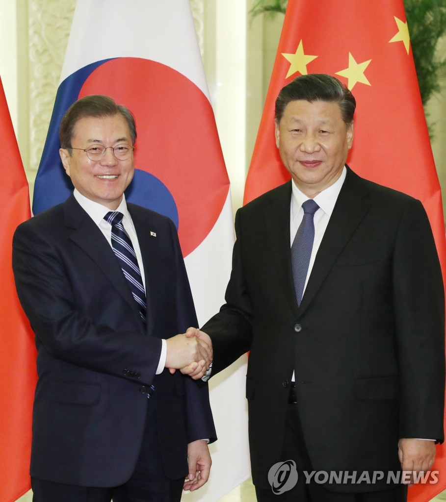 South Korean President Moon Jae-in (L) shakes hands with Chinese President Xi Jinping in their summit at the Great Hall of the People in Beijing on Dec. 23, 2019. (Yonhap)