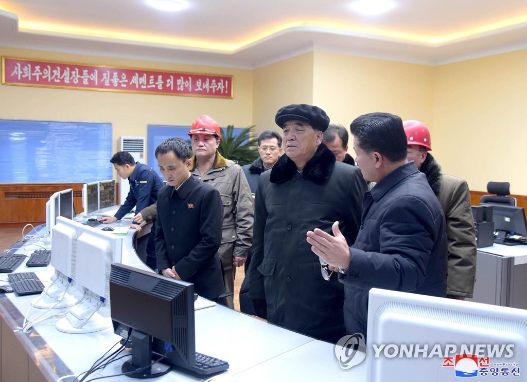 Pak Pong-ju (C), vice chairman of North Korea's State Affairs Commission, listens to an official as he inspects a cement complex, in this photo released by the Korean Central News Agency on Dec. 27, 2019. (For Use Only in the Republic of Korea. No Redistribution) (Yonhap) 