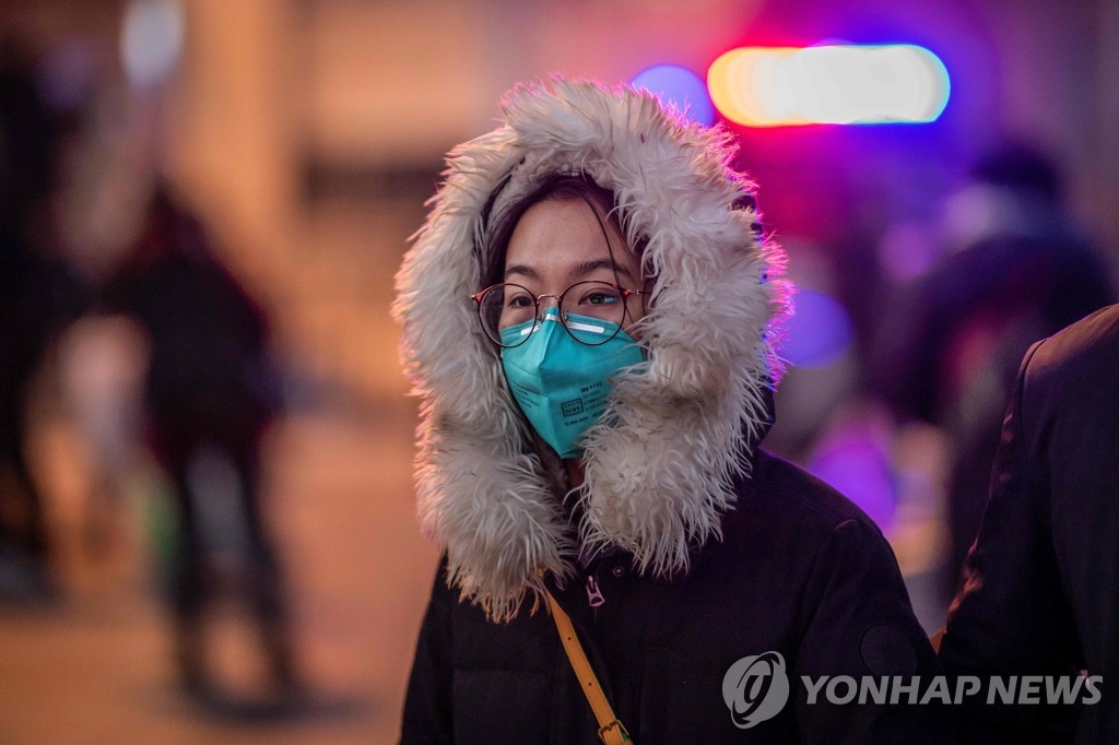 베이징 기차역 앞의 마스크 쓴 여성