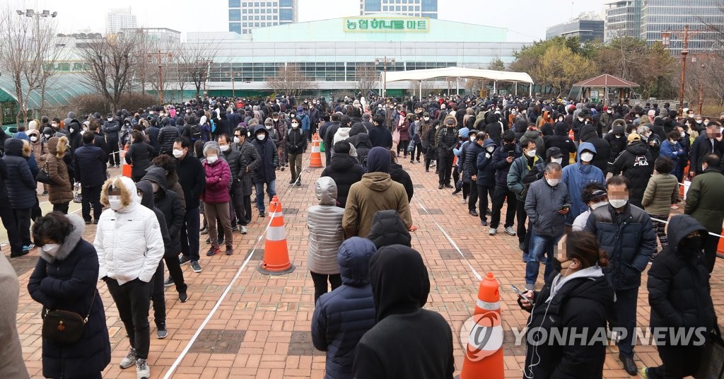 People queue in front of a supermarket in southern Seoul to purchase masks on March 4, 2020. (Yonhap)
