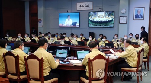 President Moon Jae-in (R) speaks during a Cabinet meeting at the presidential office Cheong Wa Dae in Seoul on March 31, 2020, which was linked via video with other Cabinet members working at the government office complex in the administrative town of Sejong, 130 kilometers south of the capital. (Yonhap)