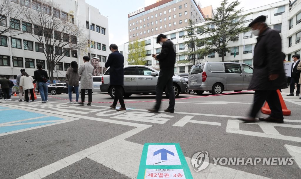 Voters stand 1 meter apart from others while waiting in line to cast ballots in early voting for the April 15 parliamentary elections at the office of Jongno Ward in central Seoul on April 10, 2020. (Yonhap)