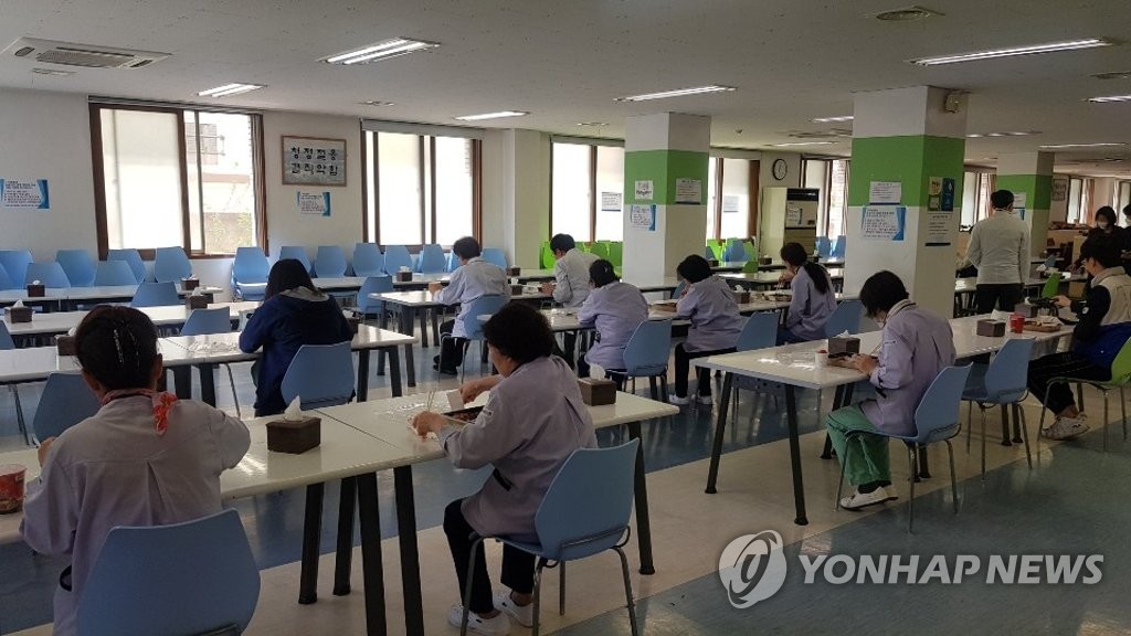 Medical staffers each eat lunch alone while facing one direction at a cafeteria in a hospital in coronavirus-hit Daegu, 300 kilometers southeast of Seoul, on April 27, 2020, in order to prevent any possible infections between them. (Yonhap)