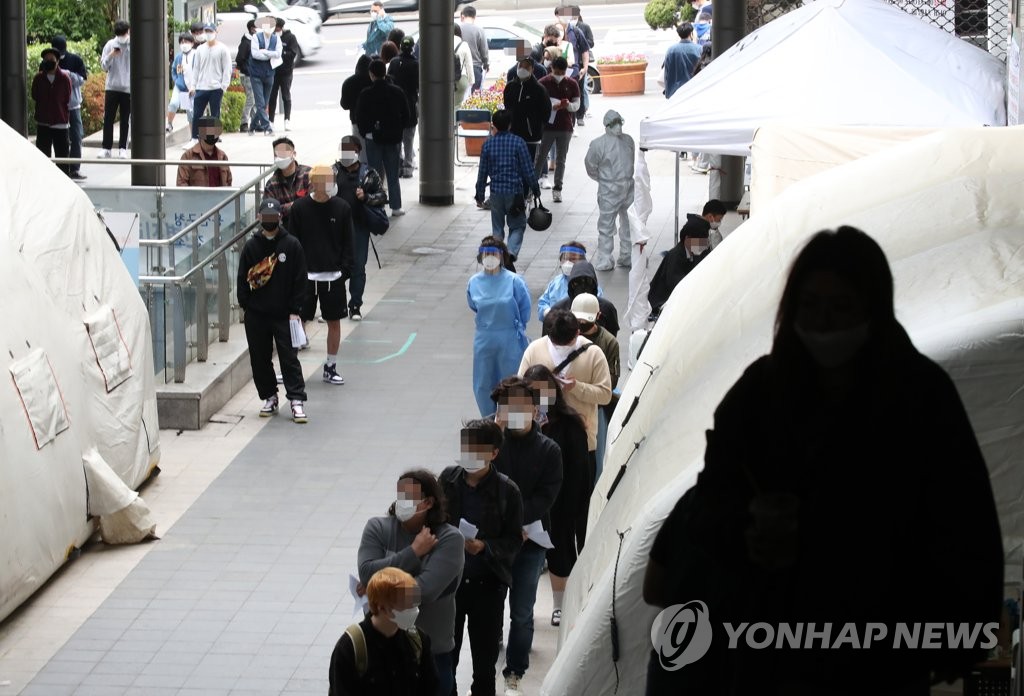 People stand in line as they wait to be checked for the coronavirus at a screening center run by Yongsan Ward in central Seoul on May 12, 2020. (Yonhap)