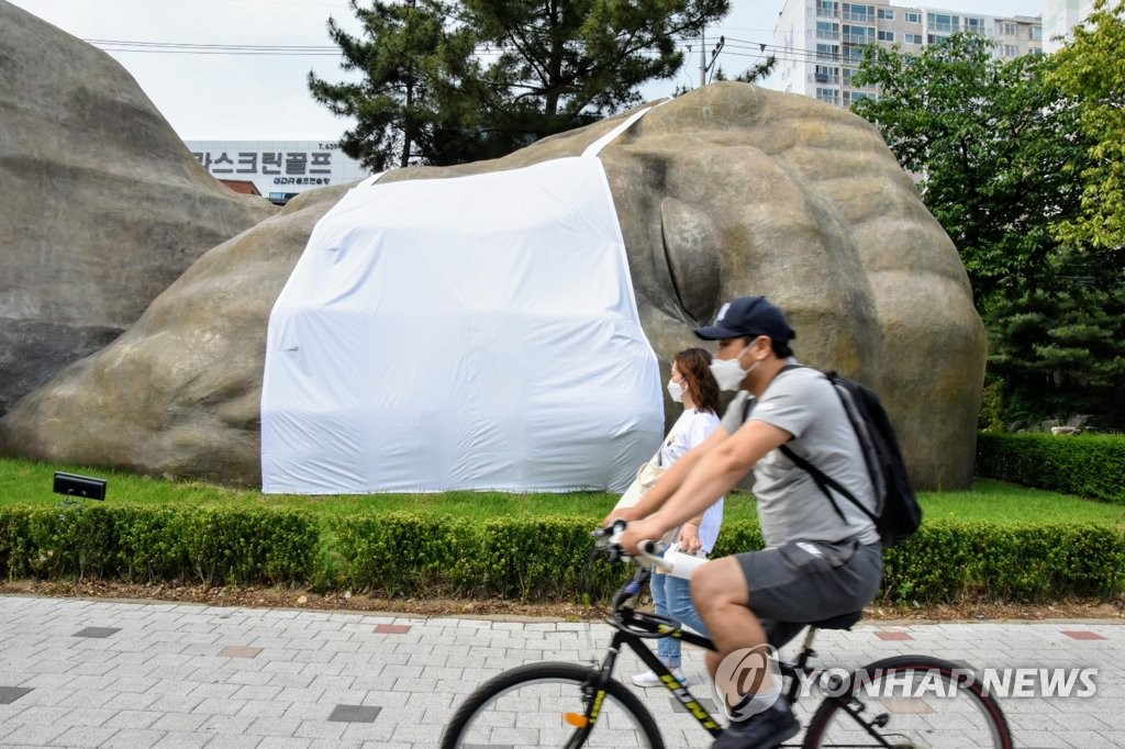 A cyclist passes a sculpture wearing a protective mask in Daegu, around 300 kilometers south of Seoul, in this photo provided by the Dalseo district of the city on May 17, 2020. The project is aimed at raising awareness of the coronavirus pandemic. (PHOTO NOT FOR SALE) (Yonhap)