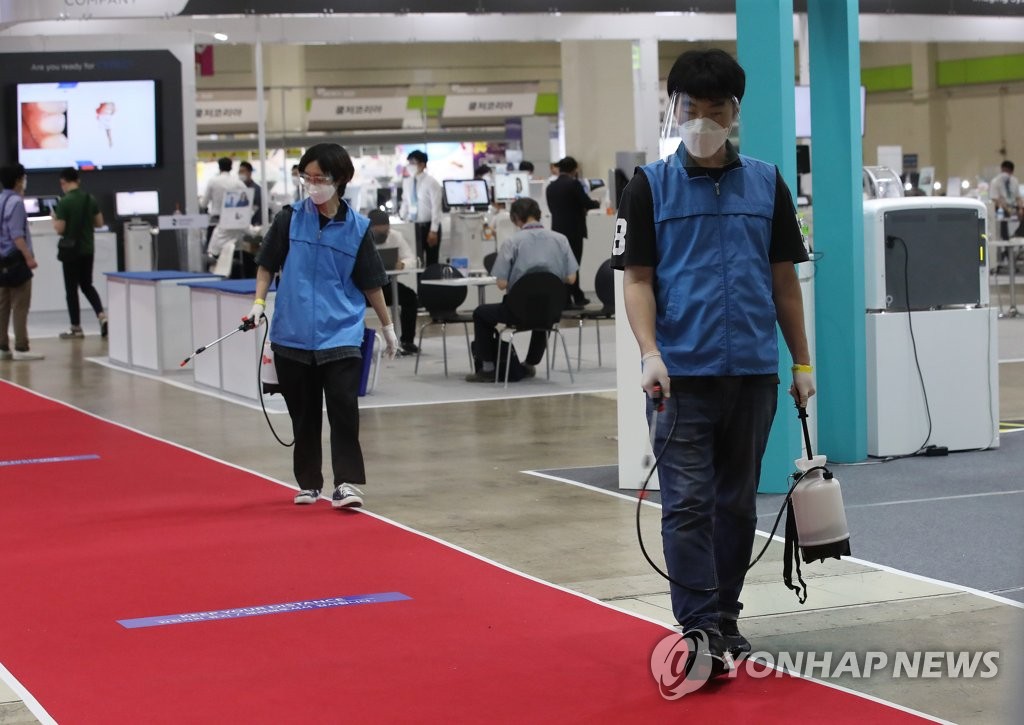 Officials disinfect hallways at the COEX convention center in southern Seoul on June 7, 2020. (Yonhap)