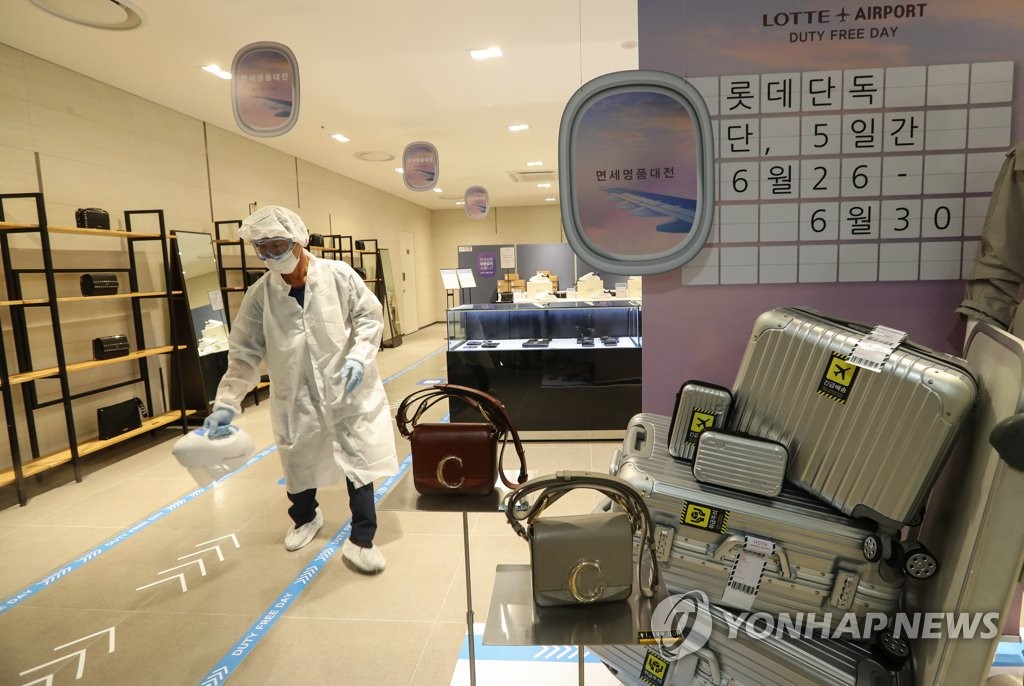 A health worker disinfects the Lotte Department Store in the southeastern city of Daegu on June 26, 2020, the first day of a state-led sales festival. (Yonhap)