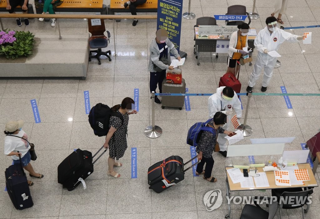 Health officials instruct international arrivals on their transportation options during the coronavirus pandemic at Incheon International Airport, South Korea's main gateway west of Seoul, on July 12, 2020, as the country began on July 13 to require arrivals from high-risk nations to hand in a certificate showing they tested negative for COVID-19. (Yonhap)