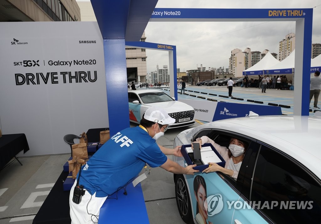 A customer receives Samsung Electronics Co.'s Galaxy Note 20 phone during SK Telecom Co.'s drive-through delivery event in eastern Seoul on Aug. 13, 2020. (Yonhap)